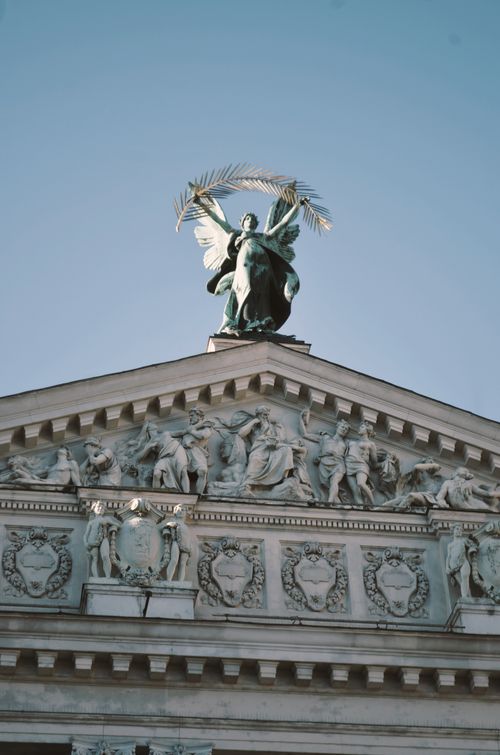 Free Detailed view of ornate architectural sculpture and angel statue on classical building facade. Stock Photo