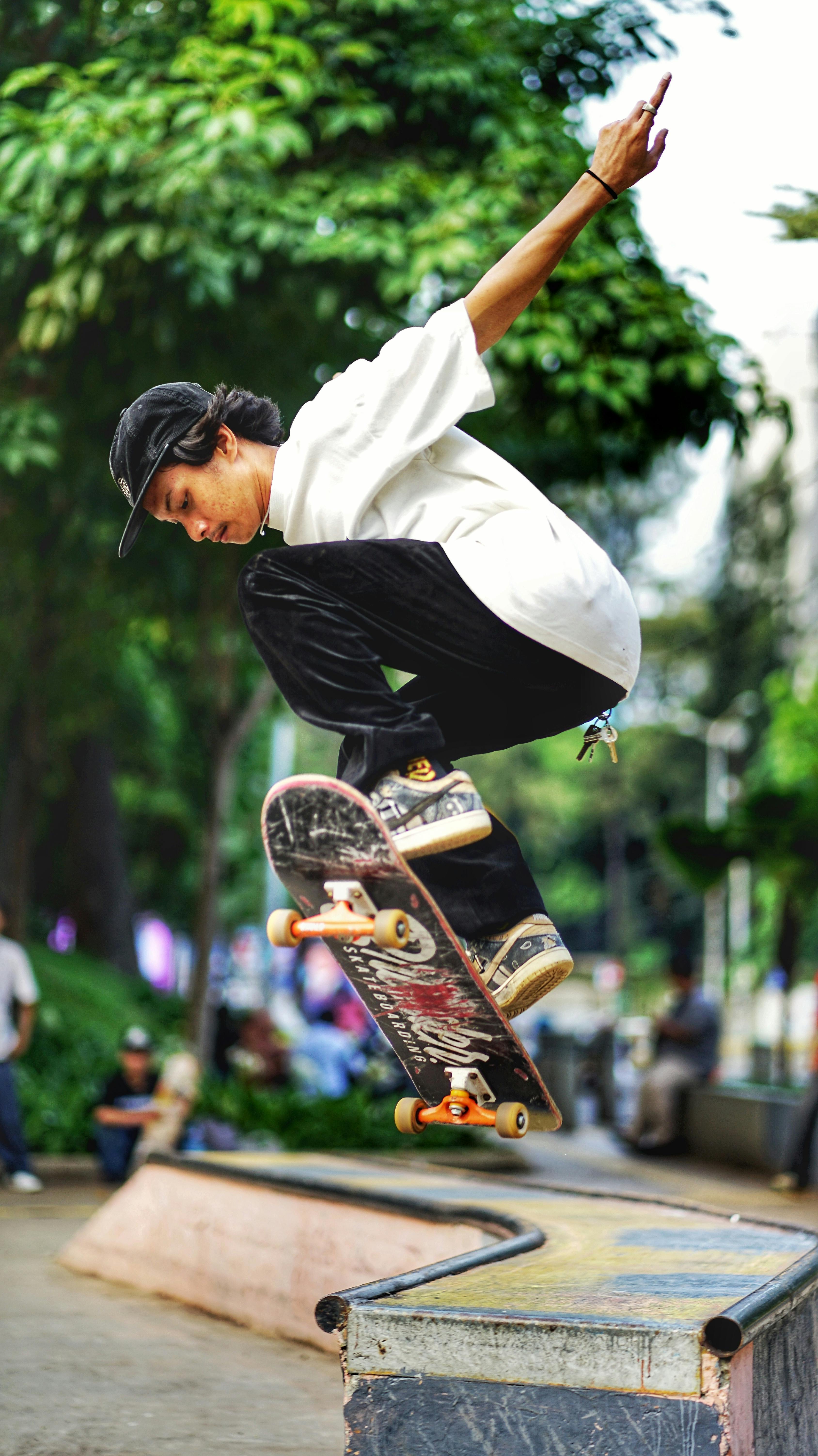 Energetic skateboarder performing a mid-air trick in a vibrant park setting, showcasing athletic skill and style.