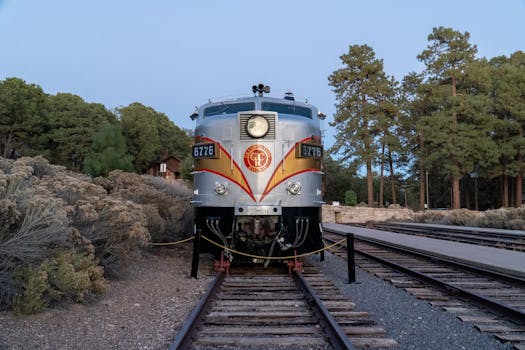 A classic train engine parked at Grand Canyon Railway surrounded by forest trees.