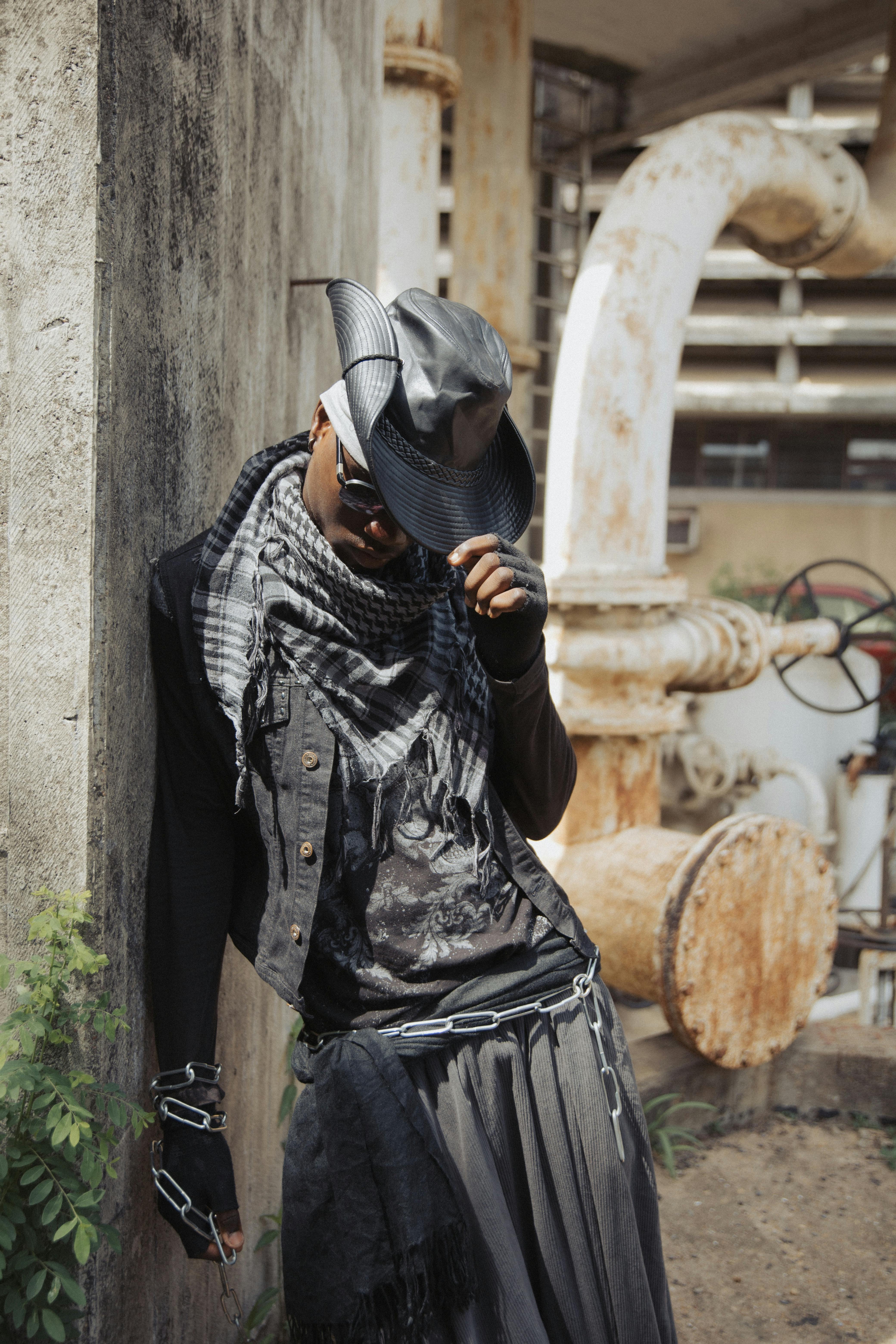 grátis Uma pessoa em traje elegante posando em um ambiente industrial urbano. Foto profissional