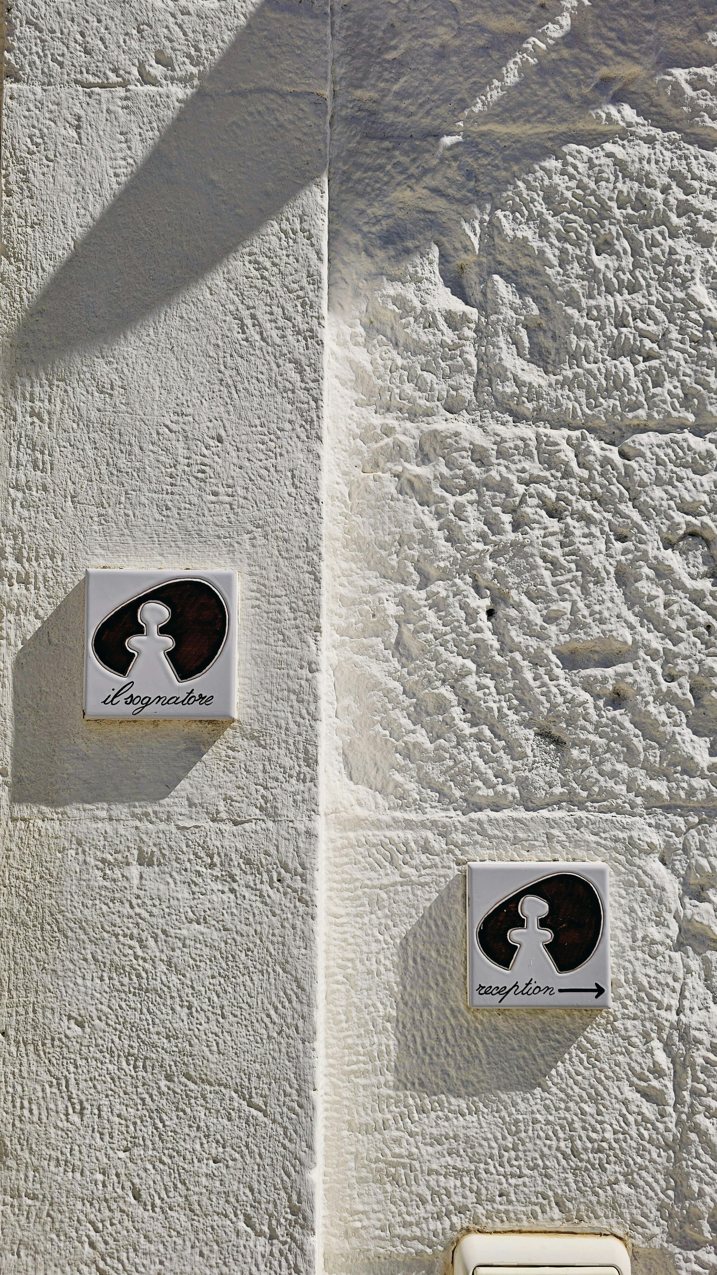 Stone wall with male and female directional restroom signs showing textured surface.