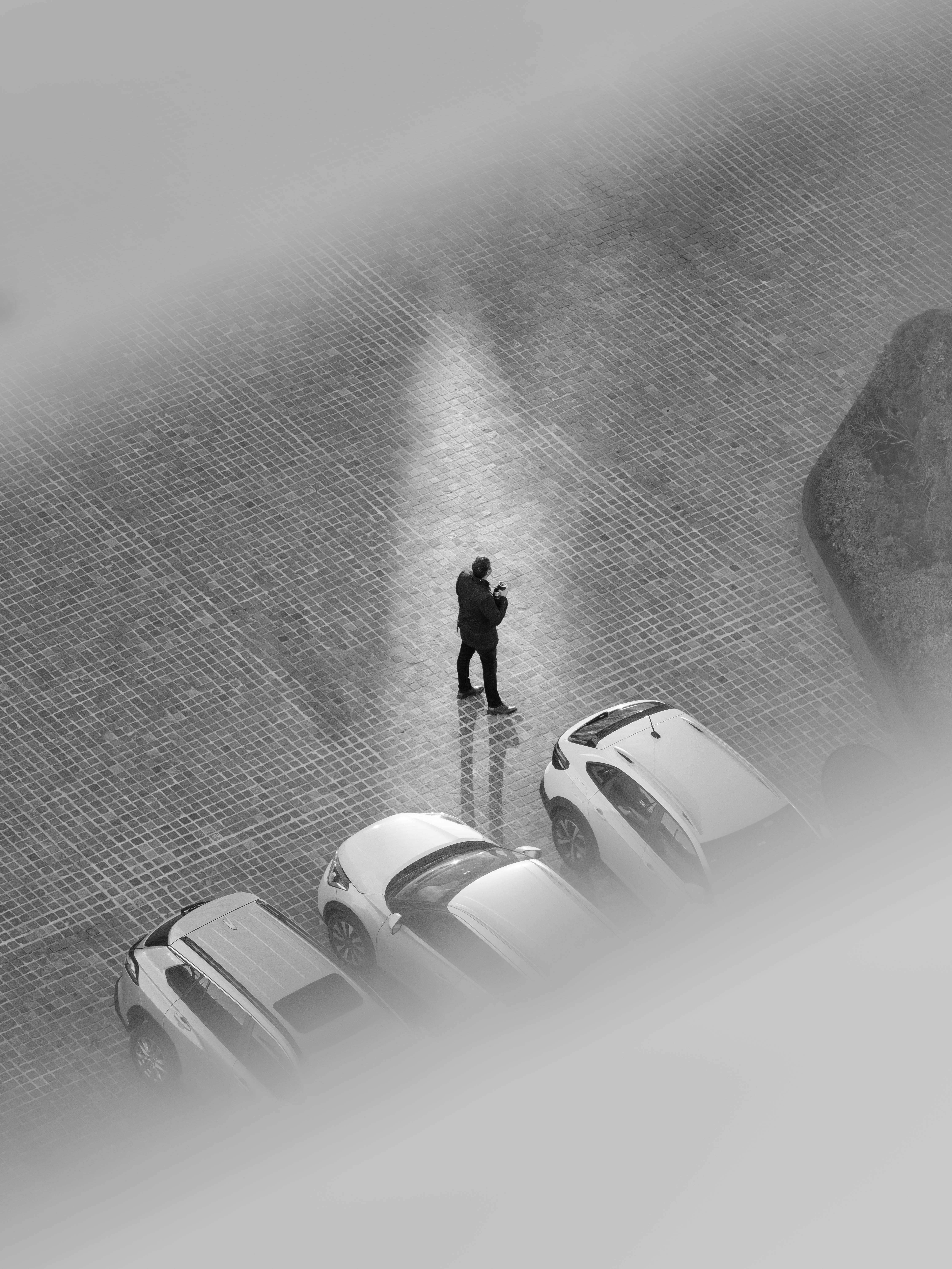 Gratuit Photographie aérienne en noir et blanc d'une personne marchant parmi des voitures garées à Montevideo. Photos