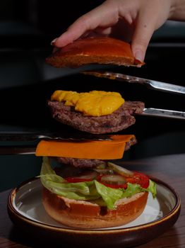 Close-up of a deconstructed cheeseburger with layers of fresh ingredients.