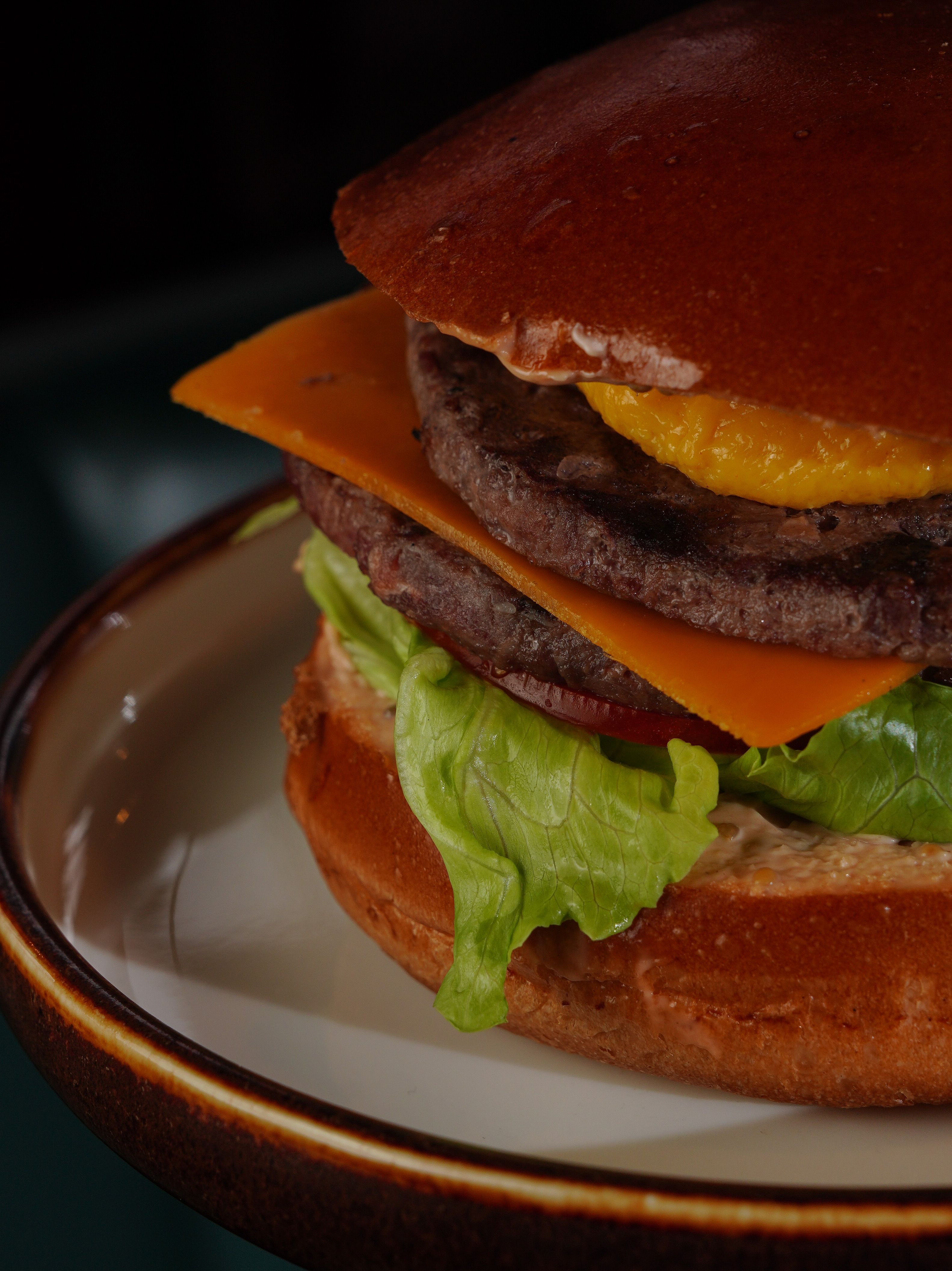 Close-up of a delicious burger with beef patty, cheese, and fresh lettuce.