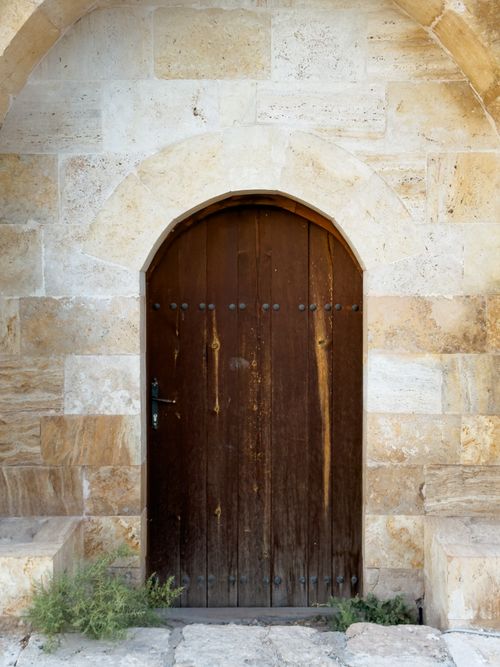 Free Historic wooden door set in a stone archway in Palu, Türkiye. Stock Photo