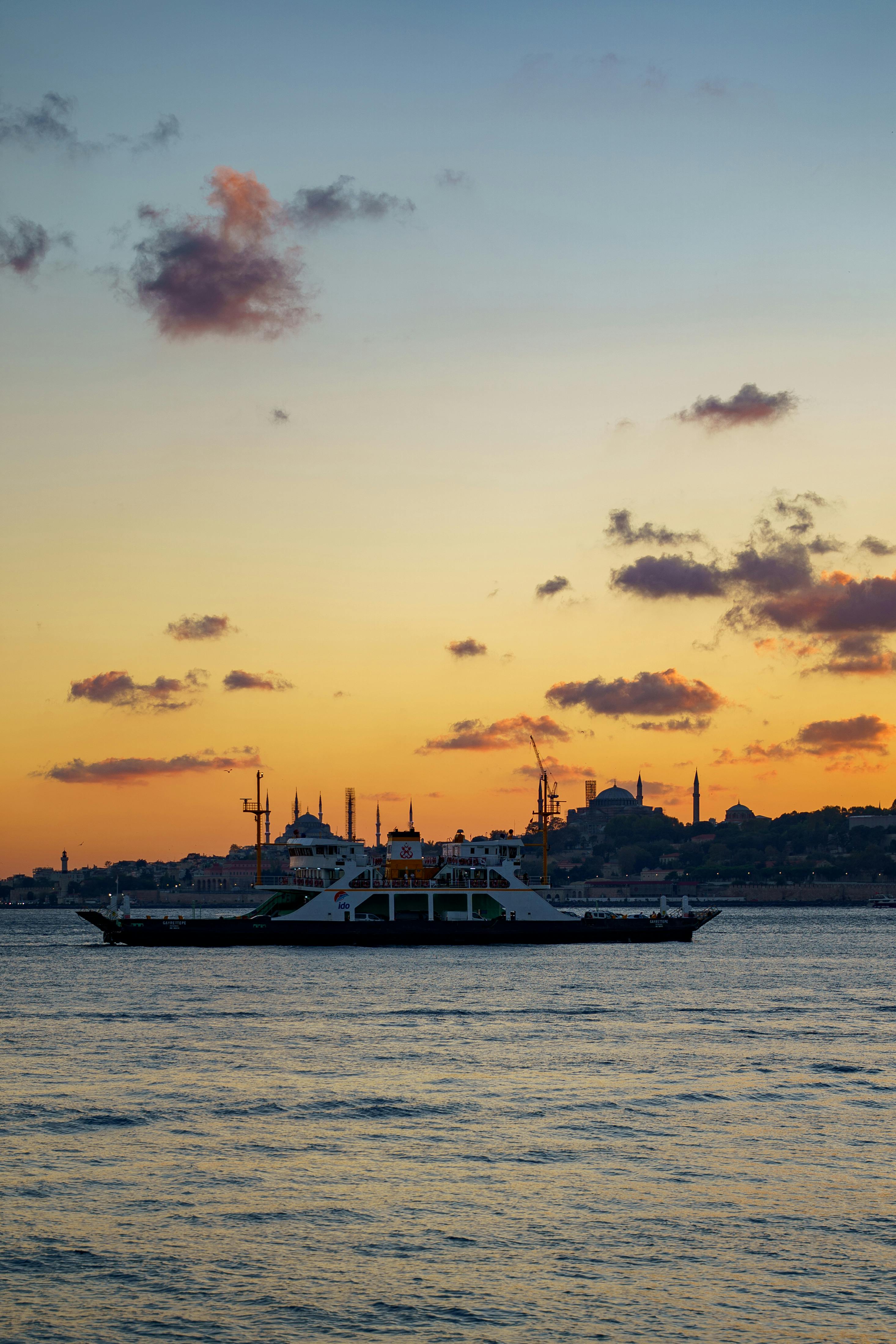 Gratuit Ferry traversant le Bosphore au coucher du soleil avec la ligne d'horizon historique d'Istanbul en arrière-plan. Photos
