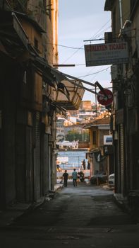 Explore the charming narrow streets of Istanbul leading to the Bosphorus, capturing daily life.