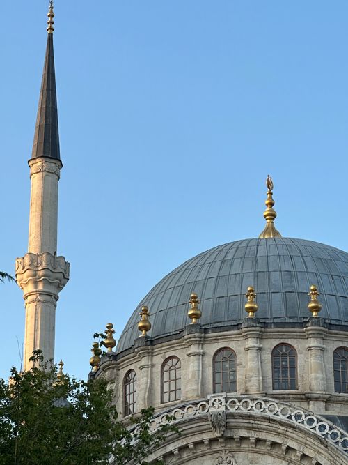 Free Close-up of a classic Ottoman mosque dome and minaret against a blue sky, showcasing architectural elegance. Stock Photo