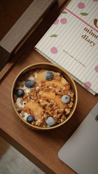 A delicious yogurt bowl with peaches, blueberries, and granola, perfect for a healthy snack or breakfast.