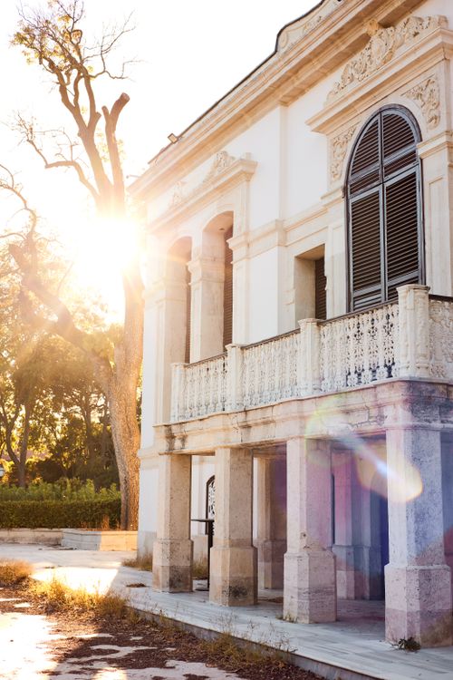 Free Sunlit historic European building with ornate details and balcony at sunset. Stock Photo
