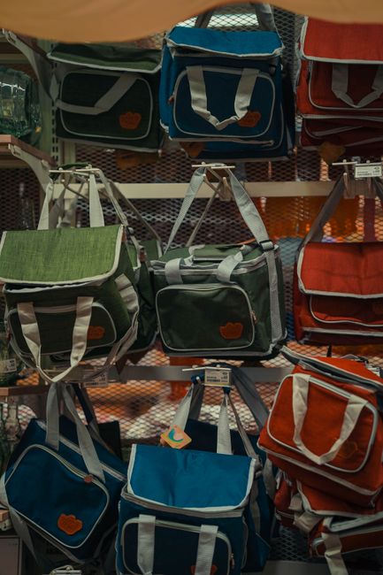 A vibrant display of canvas bags in various colors and styles on a store shelf. - Comparison of Local Brands vs. International Brands