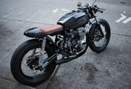 城市街道上停着一辆复古风格的摩托车，展现出经典设计