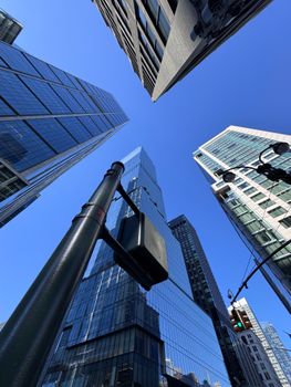 Looking up at modern skyscrapers with a deep blue sky background.