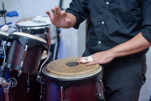 Close-up of a musician's hands playing congas indoors, highlighting rhythm and percussion. — photo by Gonzalo 8a