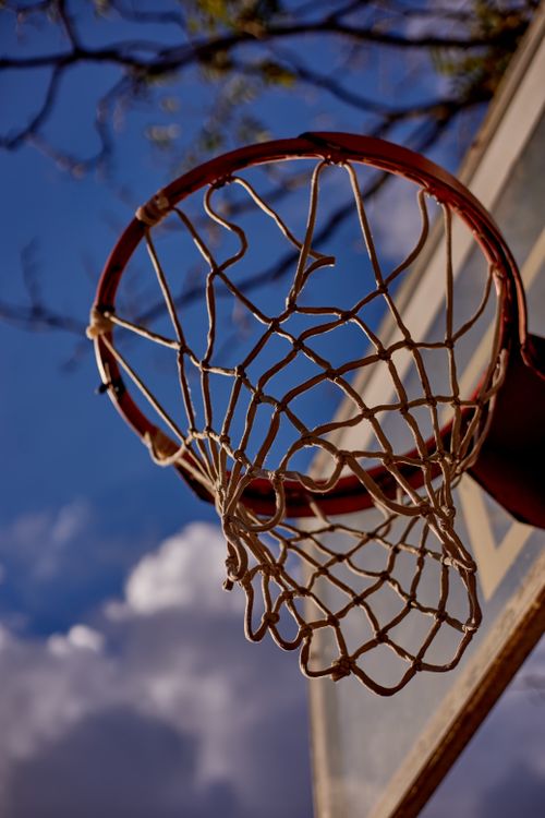 Free Outdoor basketball hoop with net captured against a vibrant blue sky in İstanbul, Türkiye. Stock Photo