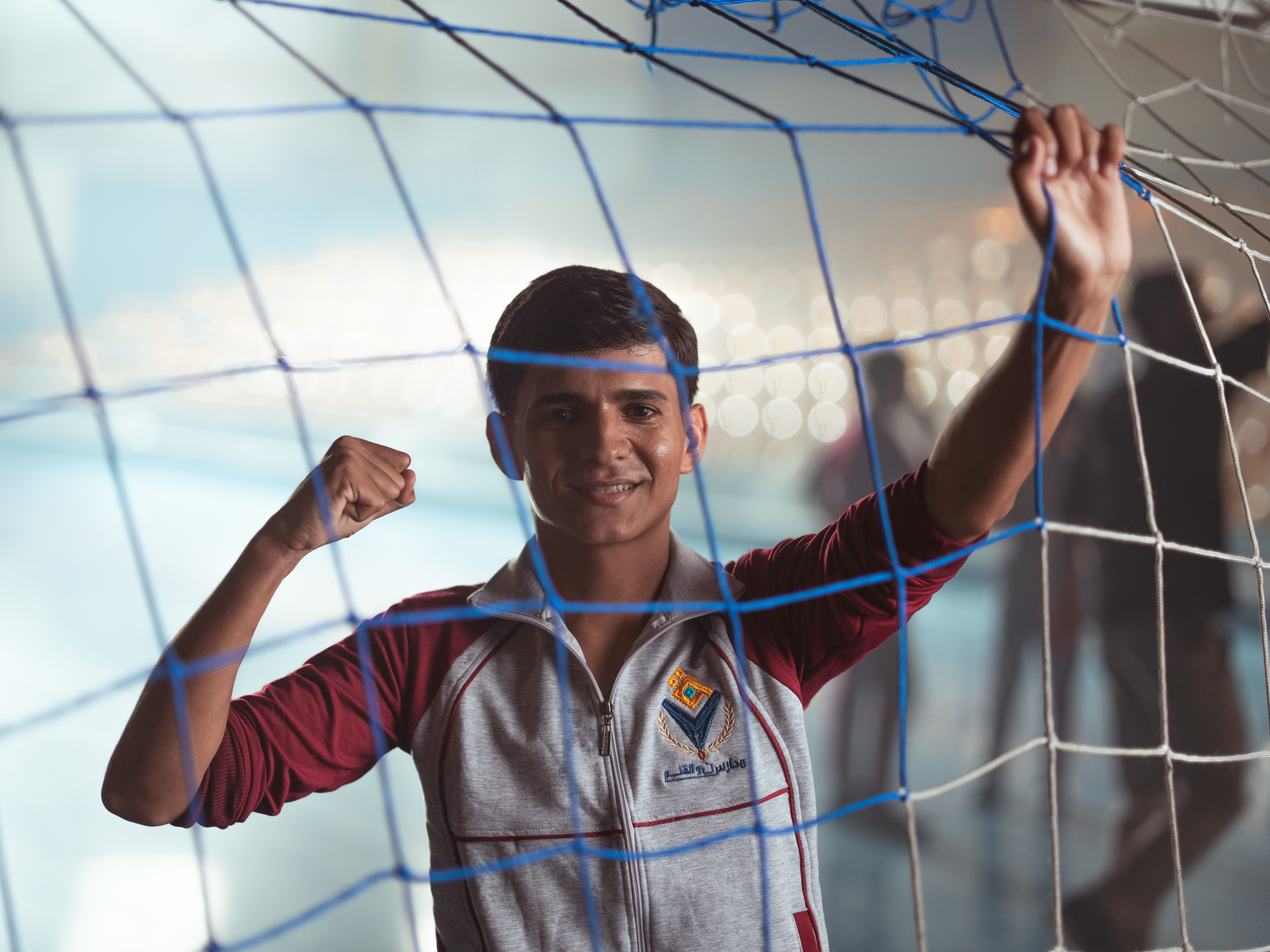 Teenager inside soccer net at indoor stadium · Free Stock Photo