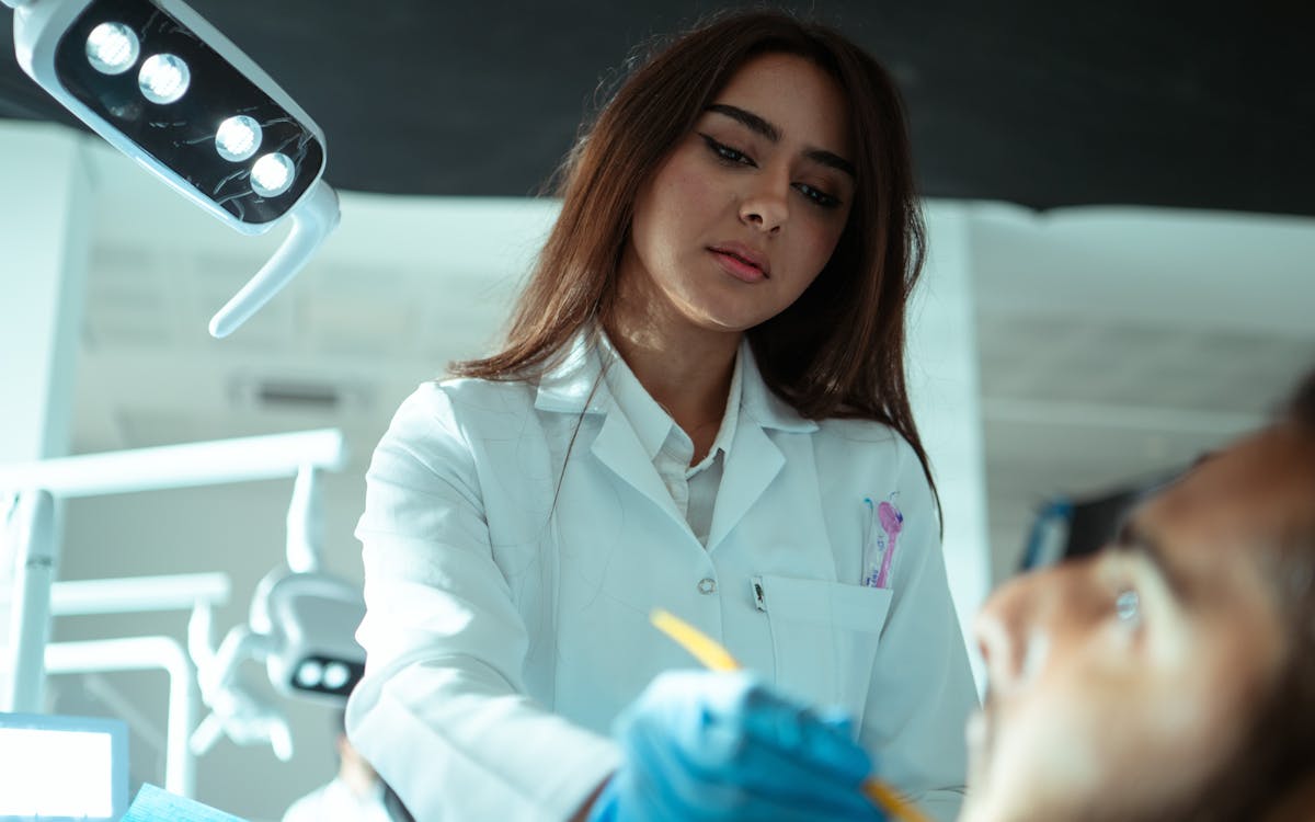 A female dentist examining a patient's teeth in a modern dental clinic.