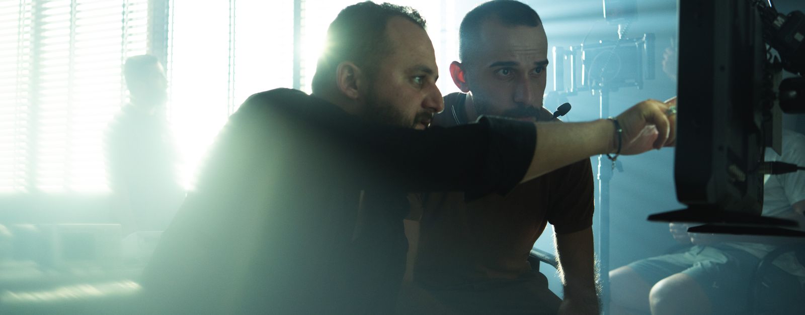 Film crew collaborating on set with cinematic lighting in Baghdad, Iraq, showcasing teamwork and creativity.