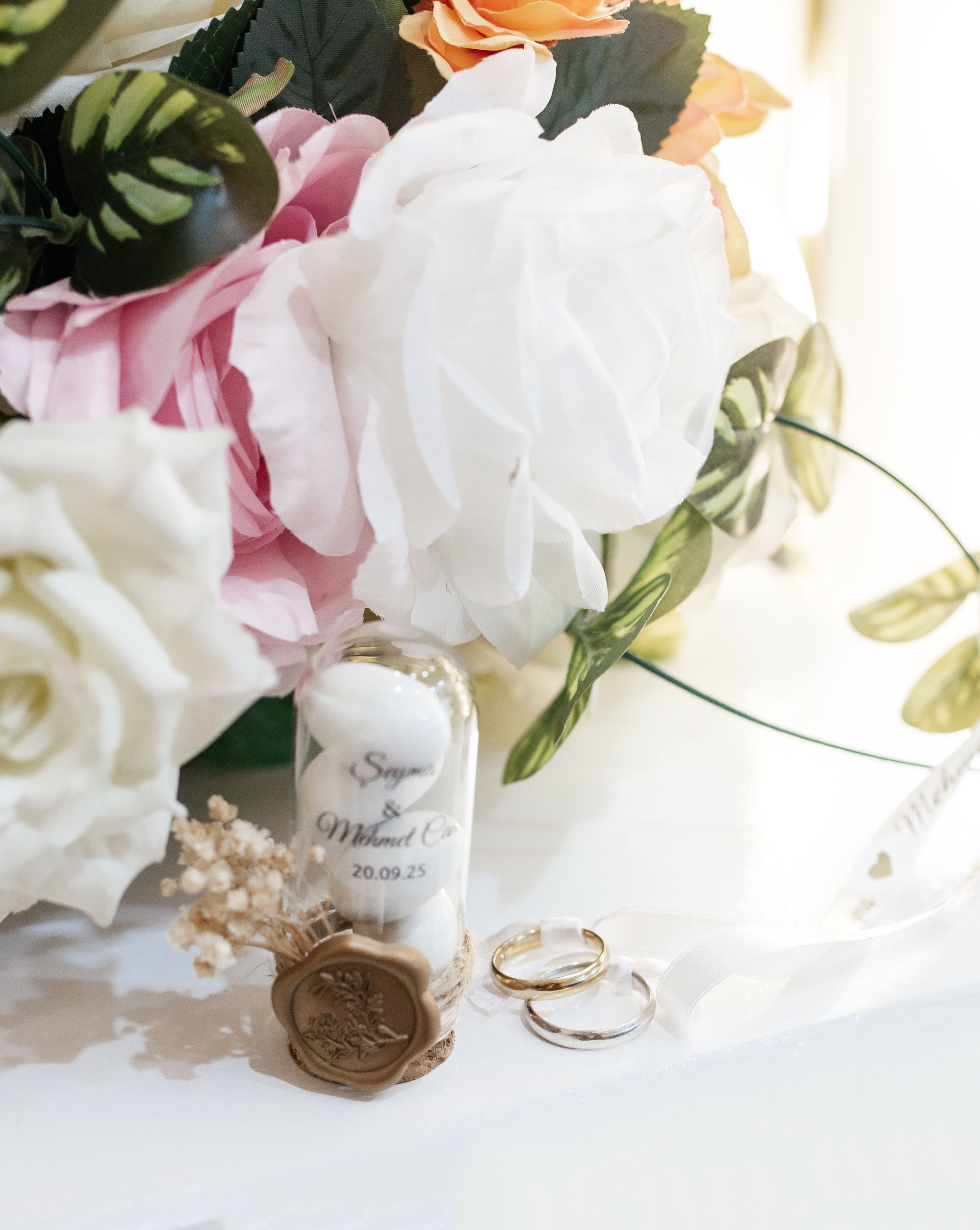 Beautiful wedding scene with flower bouquet, rings, and date jar.