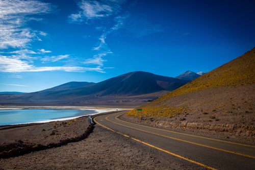 Free A breathtaking view of a winding road in the Atacama Desert with mountains and a blue sky. Stock Photo