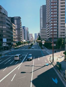 Empty city street with high-rise buildings on a sunny day in an urban setting.
