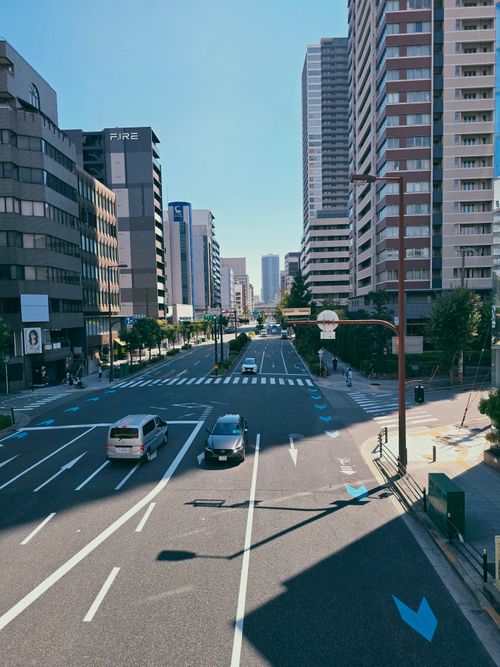 Free Empty city street with high-rise buildings on a sunny day in an urban setting. Stock Photo