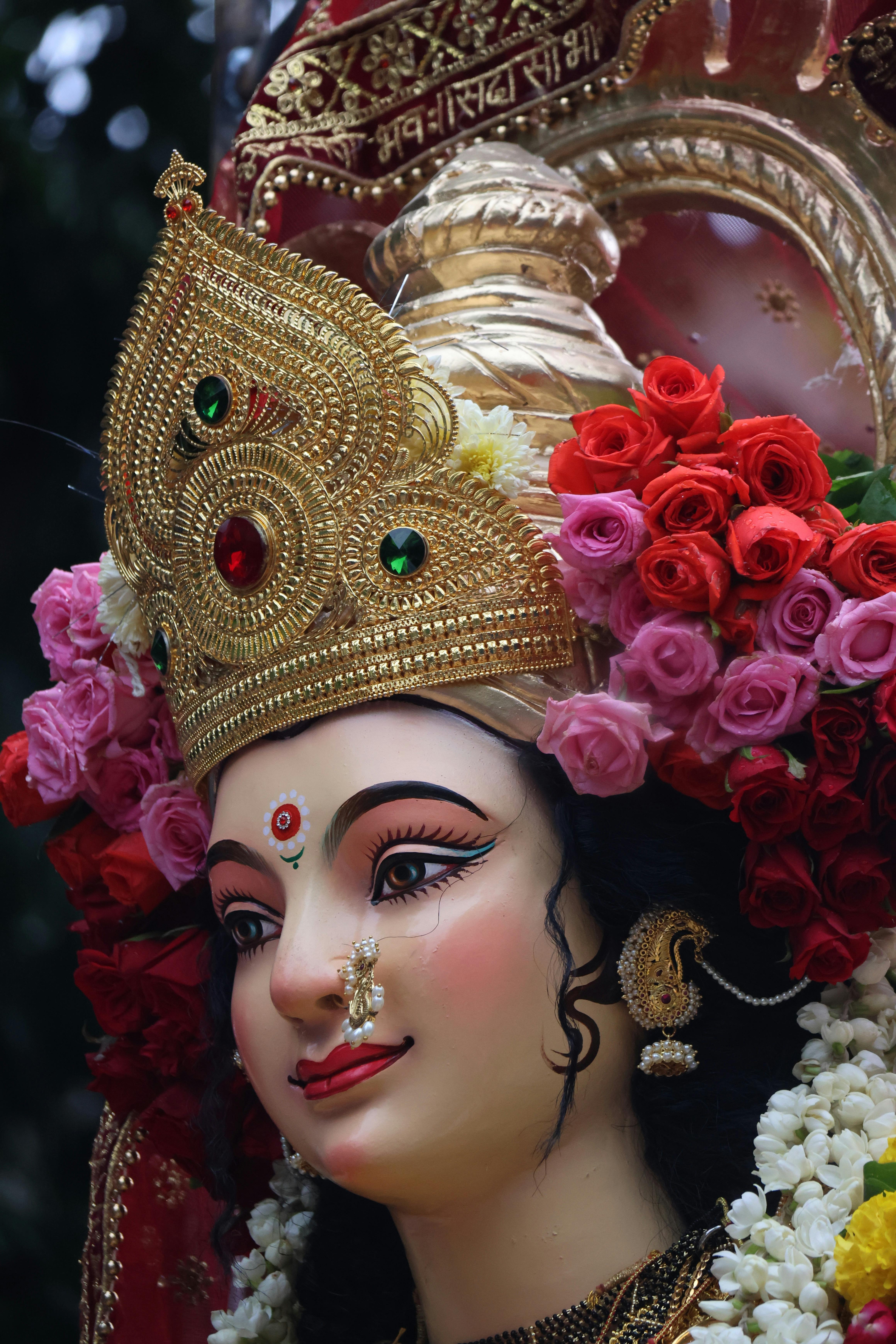 Colorful close-up of a Goddess Durga statue adorned with flowers, ideal for cultural themes.
