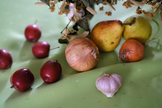 Artistic arrangement of fruits and vegetables on a vibrant green surface.