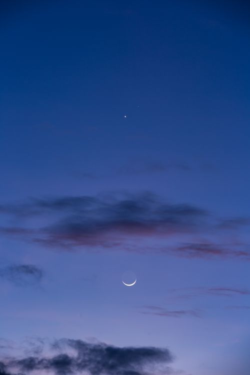 Free Beautiful crescent moon and stars shining in the twilight sky with drifting clouds. Stock Photo