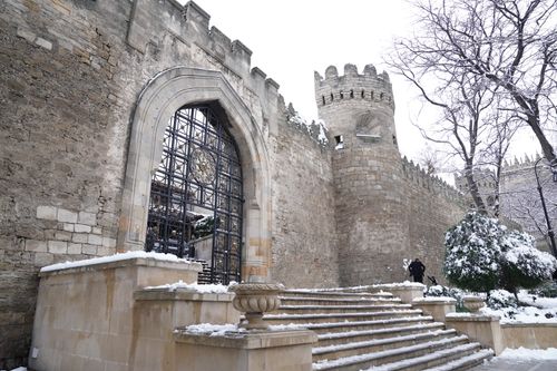 Free Snow-covered historical city walls and gate with trees in winter. Stock Photo