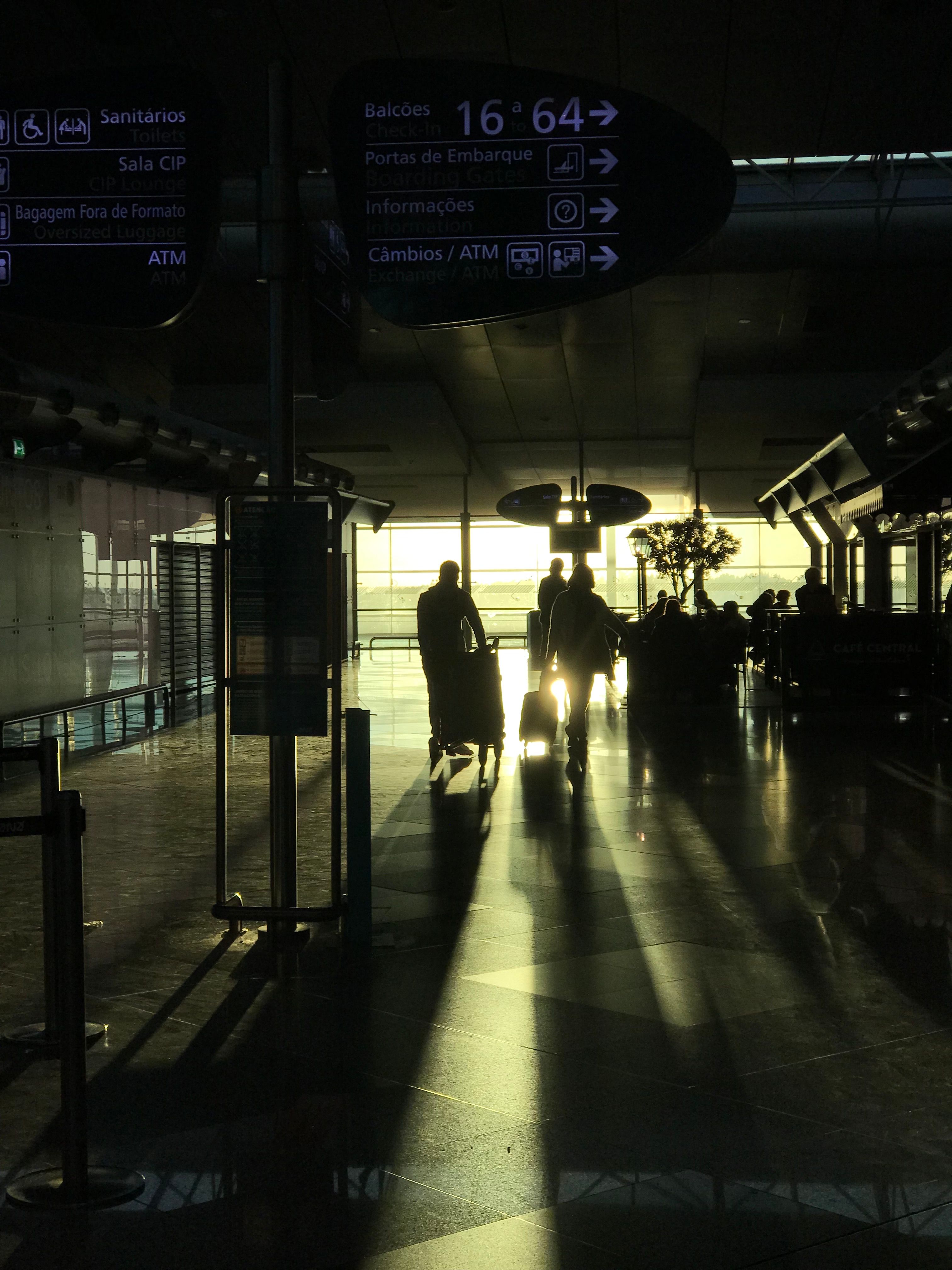 Travelers moving through a sunlit airport terminal before European border control