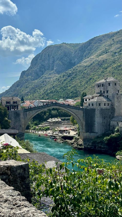 Free Stunning view of Stari Most bridge in Mostar, Bosnia, with vibrant river and mountains. Stock Photo