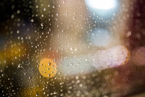 Water Drops on Clear Glass during Nightime