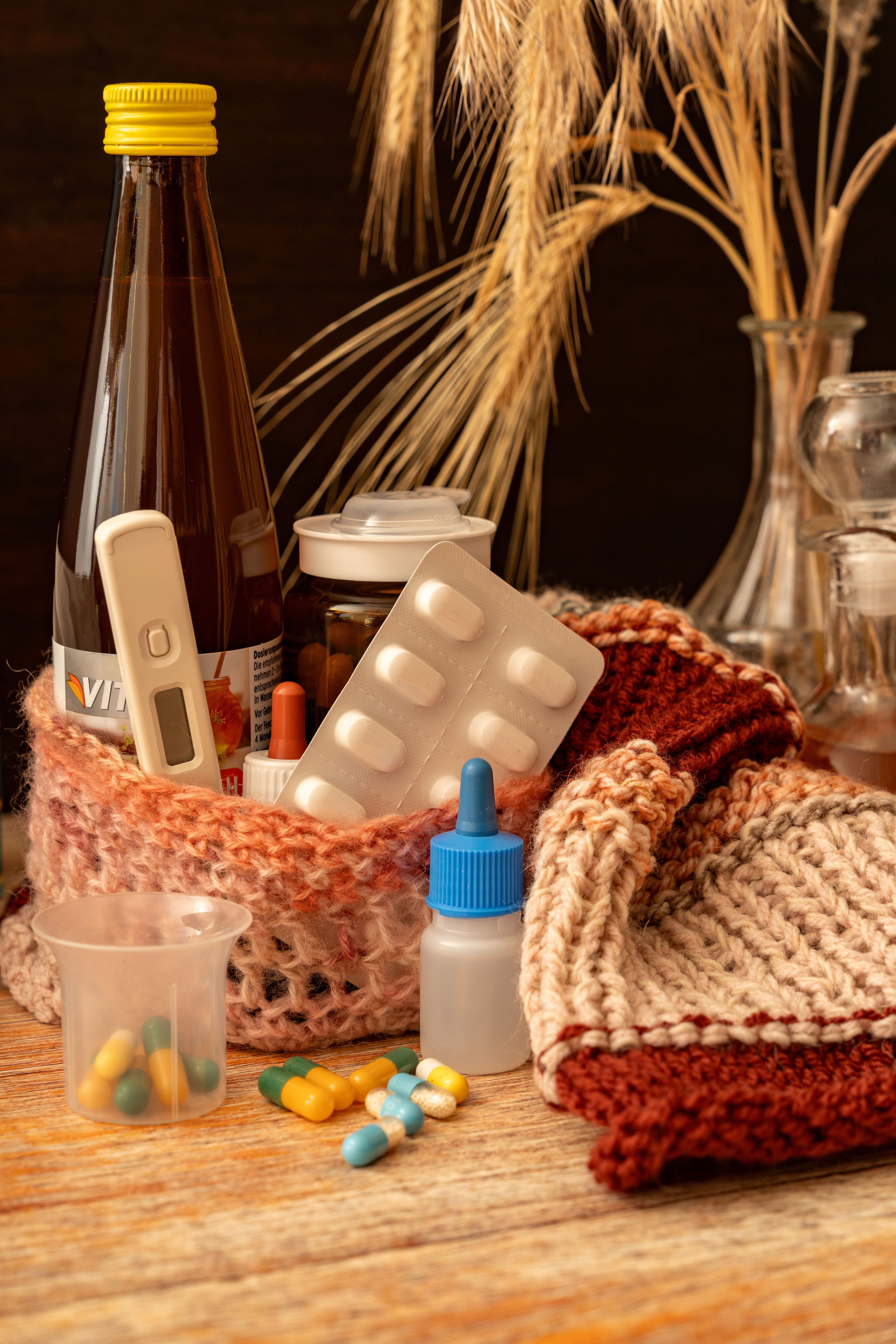 Warm knitwear with medications and hot drinks for winter illness relief. Perfect for seasonal flu remedies.