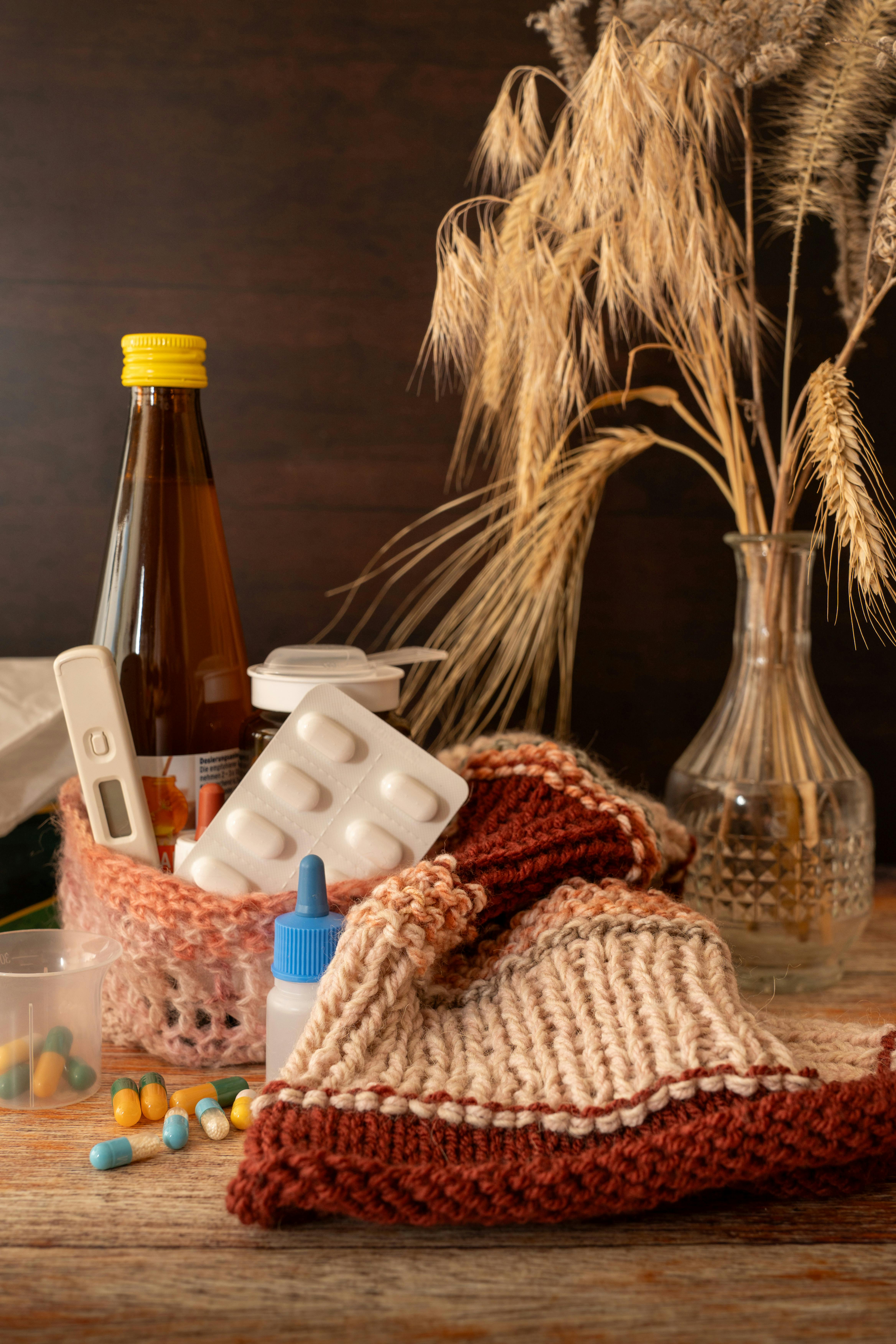Warm knitwear and flu remedies set against a cozy autumn backdrop, symbolizing health care during cold seasons.