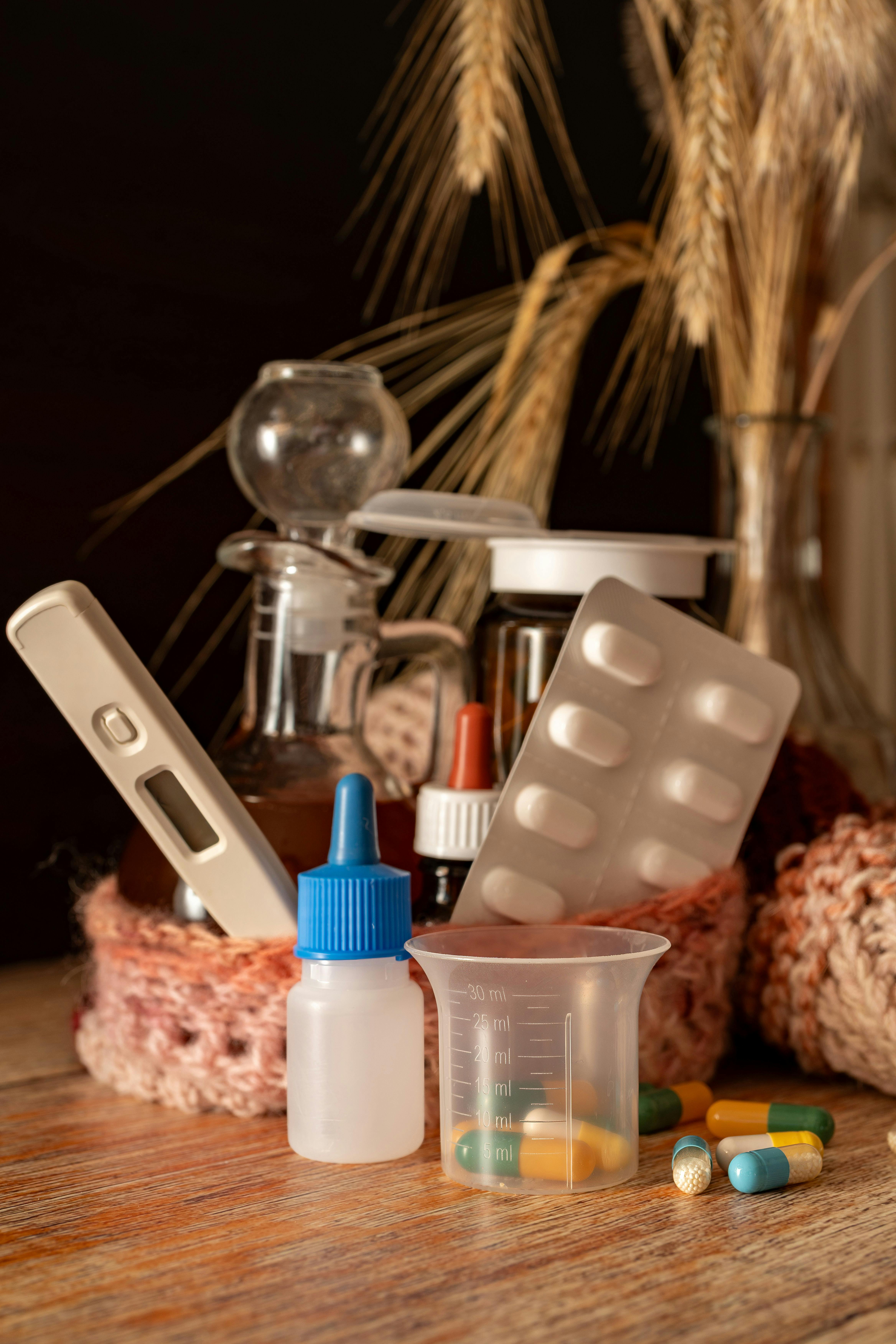 A collection of health-related items including medicine, thermometer, and herbal elements for cold season remedies.