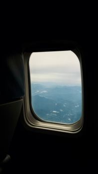 Aerial view from an airplane window capturing the mountains and sky in Da Nang, Vietnam.