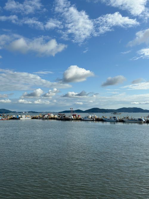 Free Peaceful dock with boats under a vibrant sky, perfect for travel and nature themes. Stock Photo