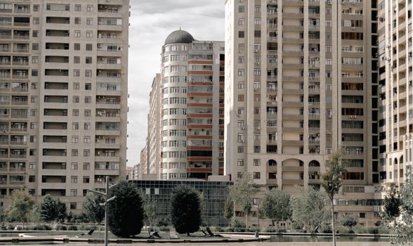 Aerial view of modern high-rise apartment buildings in an urban setting with greenery.