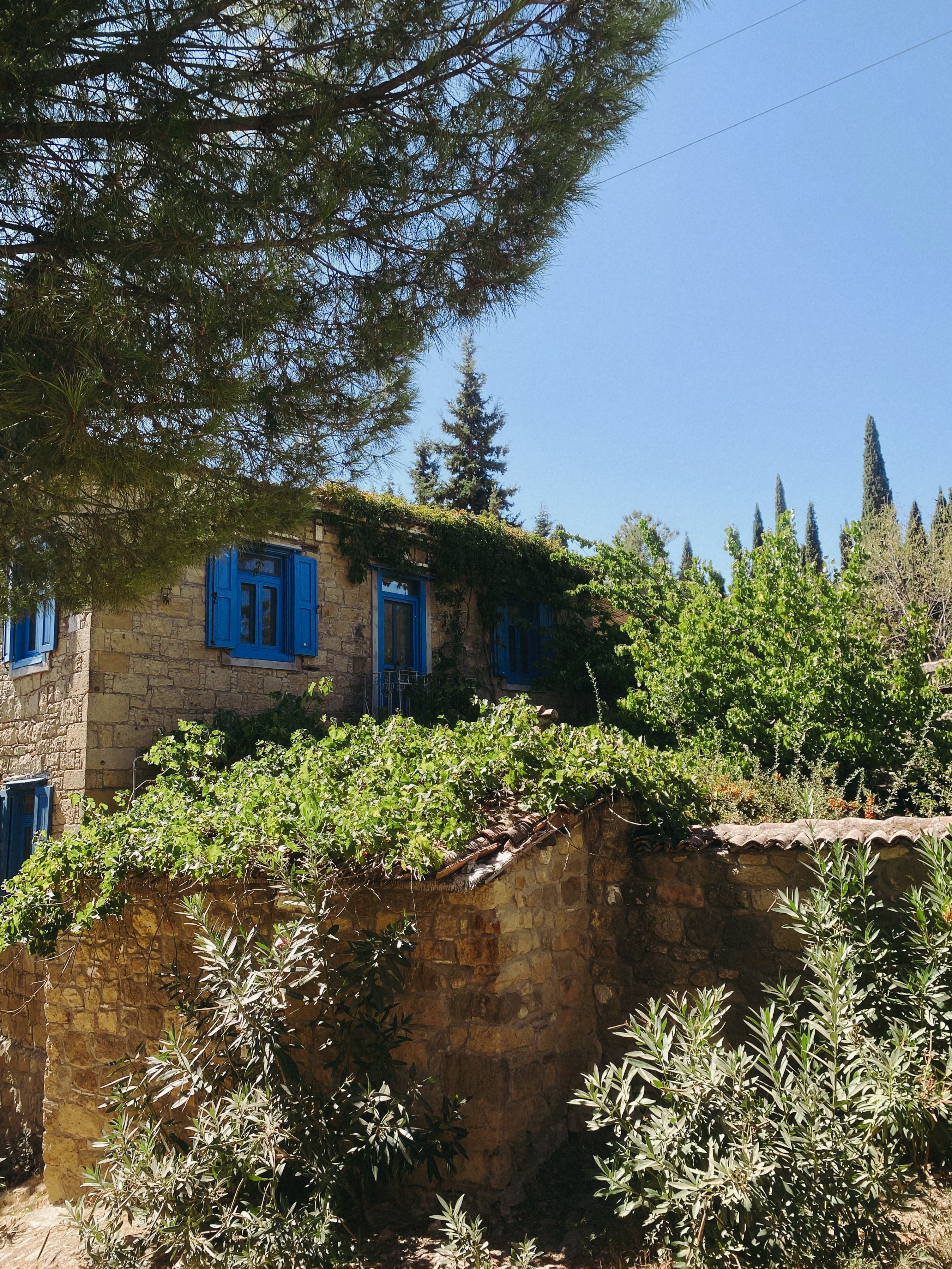 Charming Stone House with Blue Windows and Greenery · Free Stock Photo