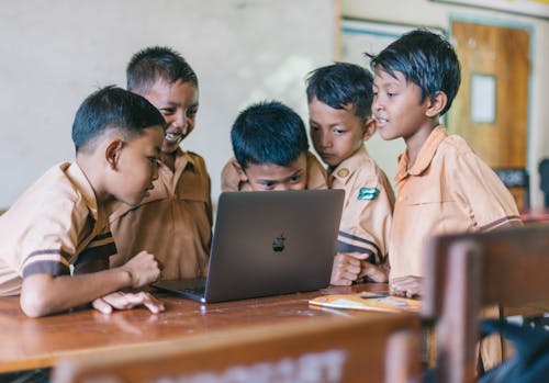 Jongen Met Behulp Van Zilveren Macbook Binnen