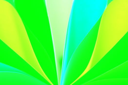 Close-up of vibrant folded paper in abstract pattern with green and blue hues.
