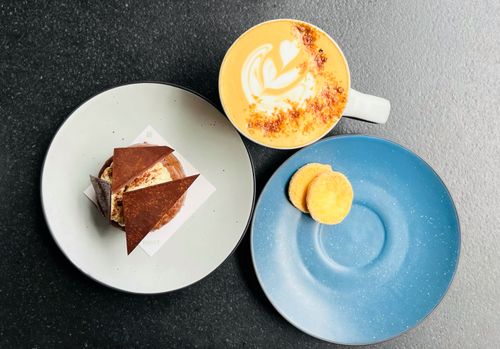 Free Flat lay of artistic latte with dessert and biscuits on elegant plates. Stock Photo