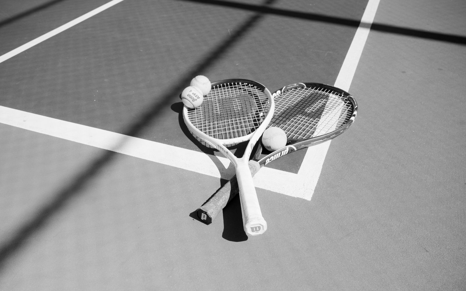 Black and white tennis racket and balls on court