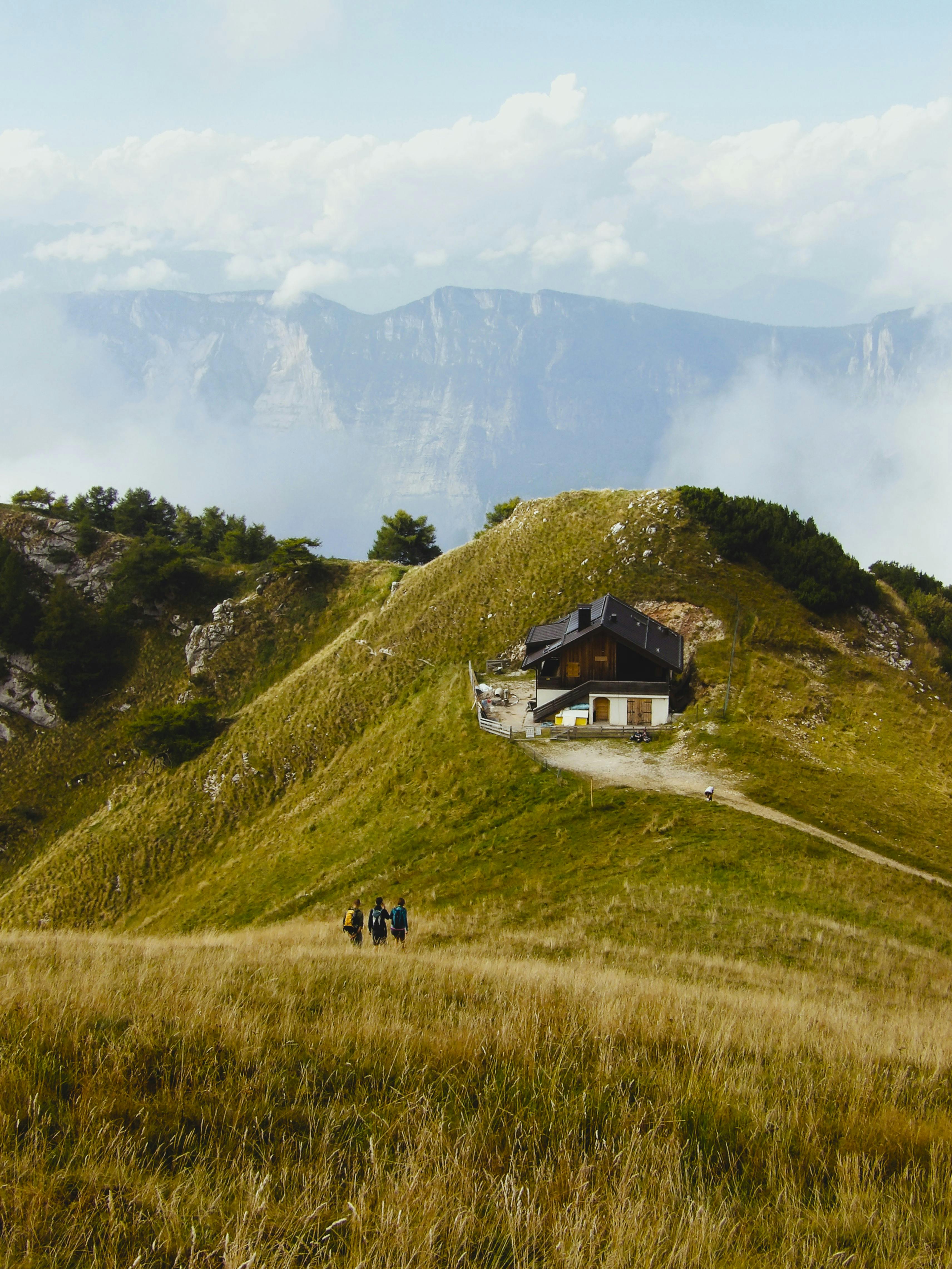 Rustic cabin surrounded by lush green hills in Trentino, ideal for nature lovers.
