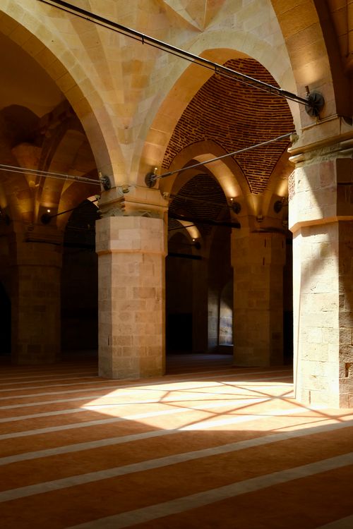 Free Historic hall with arches and sunlit patterns in an ancient architectural setting, showcasing stone craftsmanship. Stock Photo