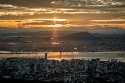 Stunning sunset skyline view from Bukit Bendera, Penang, showcasing urban and natural landscapes.
