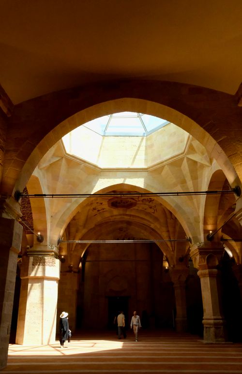 Free A historic stone hallway with dramatic arches and natural sunlight through a central skylight. Stock Photo