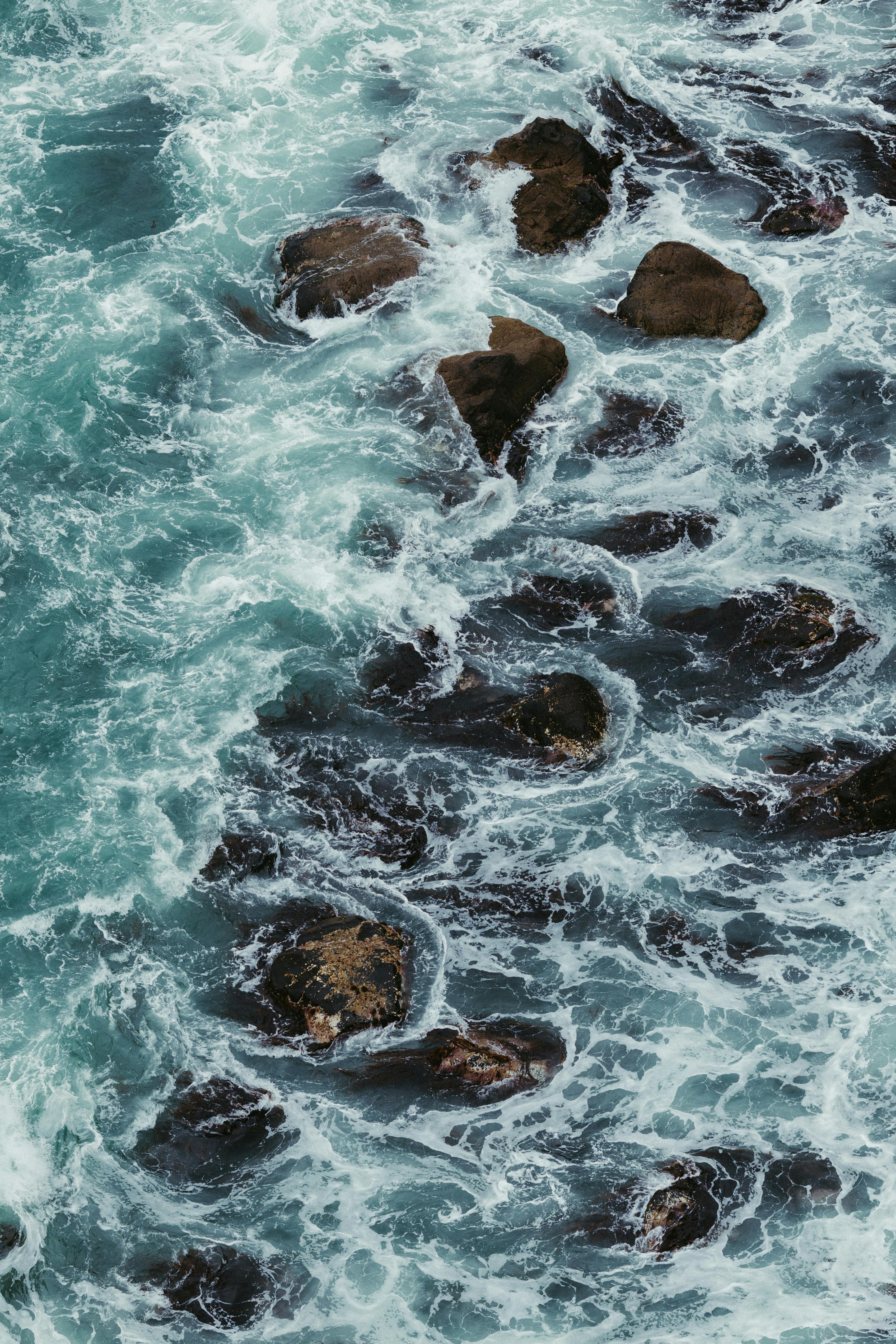Powerful ocean waves crashing against rocks, capturing the force of the sea.