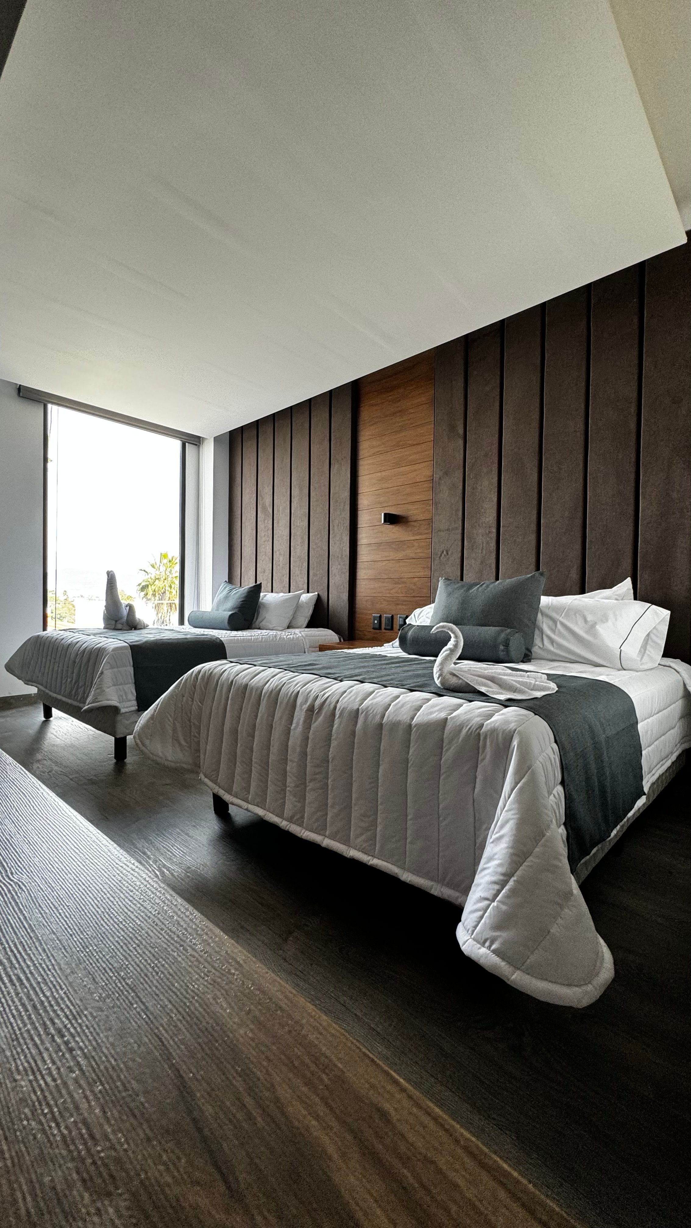 Fotomural Habitación de hotel contemporánea con dos camas y elegante decoración en León, México.